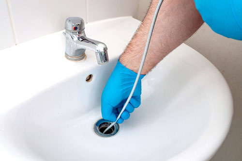 Miramar residential plumbing technician unclogging a bathroom sink